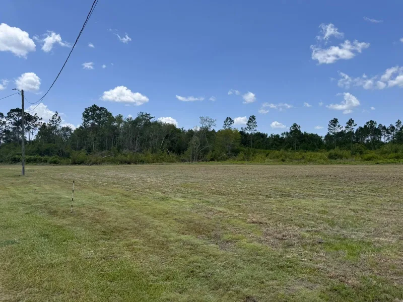After — the same field cut down flat to the treeline.
